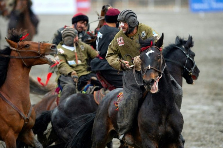 A Kunduz rider, plaster over his broken nose, joins the fray against Kandahar in Afghanistan's buzkashi grand final in Kabul