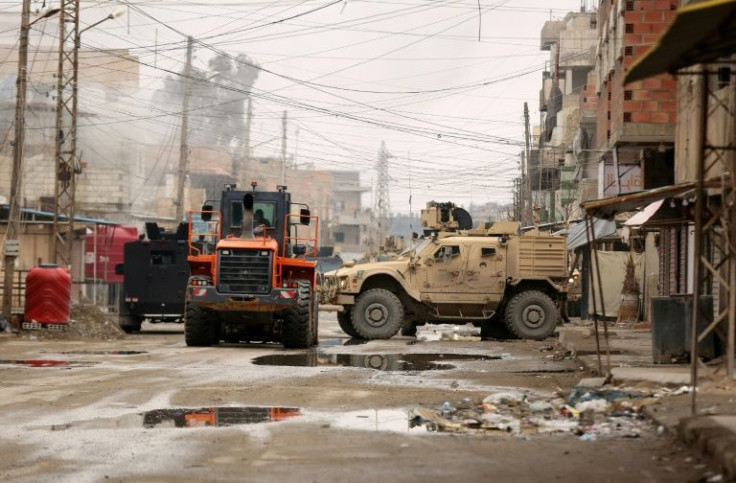 US soldiers accompanied by members of the Syrian Democratic Forces (SDF) gather in Ghwayran area of Hasakeh city on January 29, 2022 during a search for escaped prisoners believed to be affiliated with IS