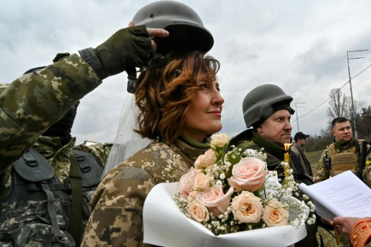 Servicemen of Ukrainian territorial defence, Valery (2ndR) and Lesya (L), get married not far from check-point on Kyiv outskirts on March 6, 2022