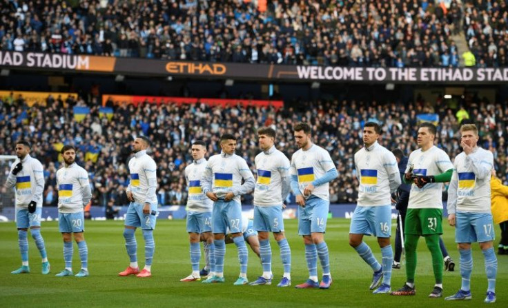 Making a stand: Manchester City players line up wearing tops with a Ukrainian flag printed on the front and the words "No War"