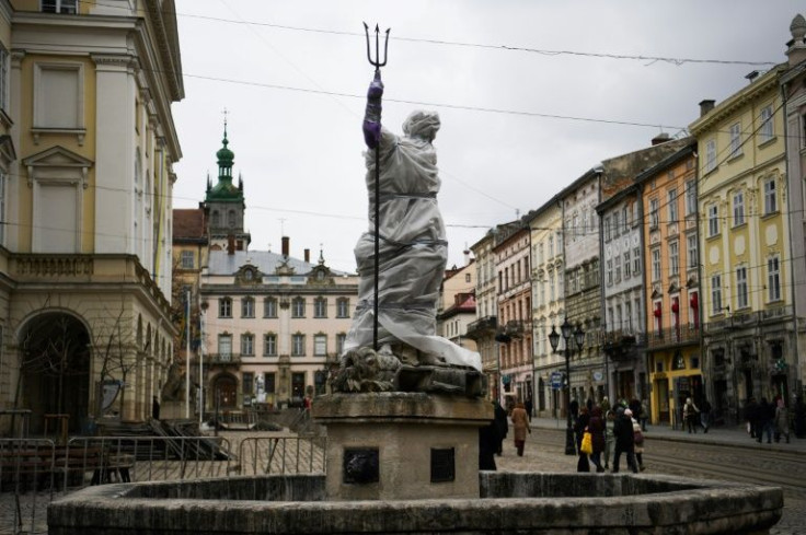 Only a trident can be seen sticking out from a statue of Neptune covered in a plastic sheet