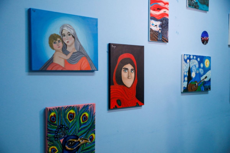 Paintings drawn by Roya Rasuli, an 18-year-old Afghan migrant artist, hang on a wall of a classroom at a camp for refugees and migrants, in Thiva, Greece, March 3, 2022. Picture taken March 3, 2022.