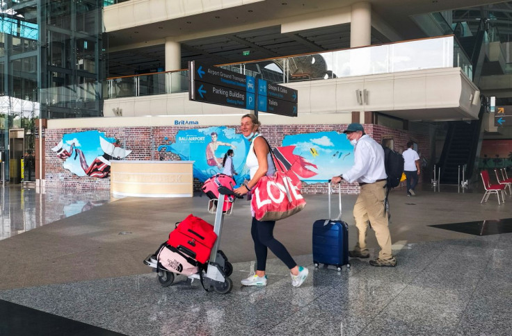 Foreign tourists carrying their luggage walk as they arrive at the I Gusti Ngurah Rai International Airport, as the local government kicks off the first day of the 'quarantine free' trial, amid the coronavirus disease (COVID-19) pandemic, in Bali, Indones