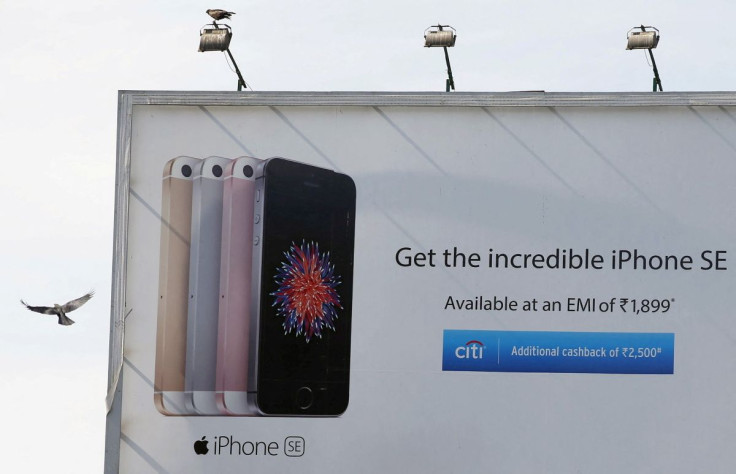 A bird flies past an Apple iPhone SE advertisement billboard in Mumbai, India, April 26, 2016. 