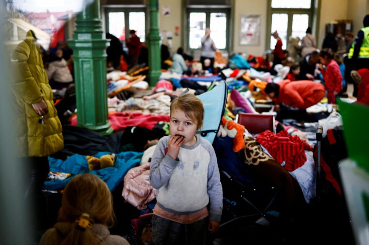 A child eats a cookie as she stands in a temporary accommodation for refugees at the train station, after fleeing Russian invasion of Ukraine, in Przemysl, Poland, March 7, 2022. 