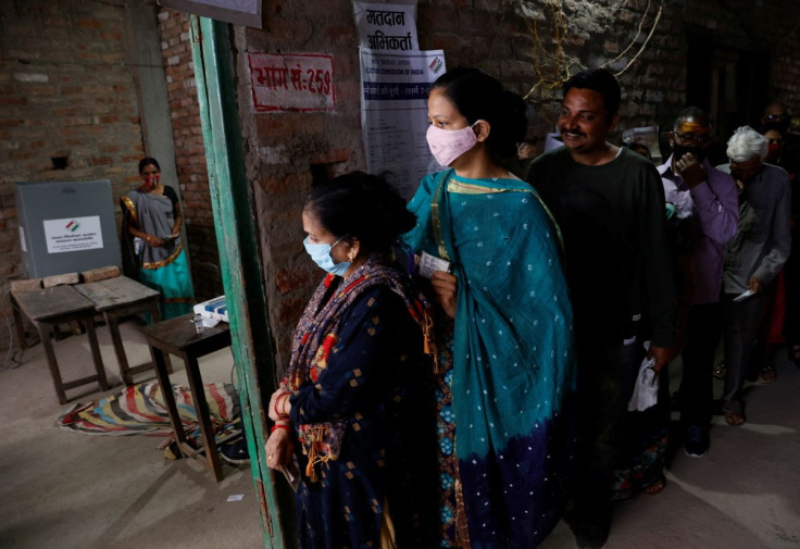 A woman leaves after casting her vote as others wait for their turn at a polling station during the last phase of state assembly election in Varanasi in the northern state of Uttar Pradesh, India, March 7, 2022.