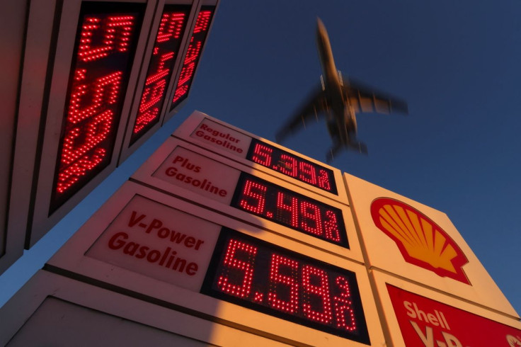An aircraft flies over a sign displaying current gas prices as it approaches to land in San Diego, California, U.S., February 28, 2022.    
