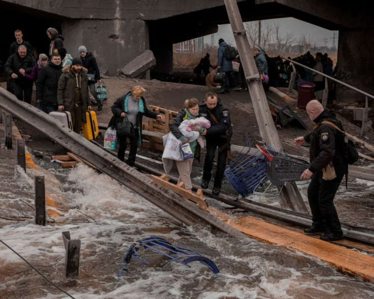 Local residents cross a destroyed bridge as they evacuate from their town in Irpin, near Kyiv, Ukraine March 7, 2022. Jedrzej Nowicki/Agencja Wyborcza.pl via REUTERS 
