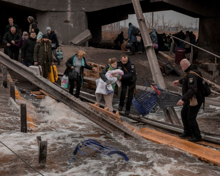 Local residents cross a destroyed bridge as they evacuate from their town in Irpin, near Kyiv, Ukraine March 7, 2022. Jedrzej Nowicki/Agencja Wyborcza.pl via REUTERS