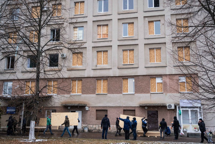 Men use sheets of plywood to cover windows of a hospital following shelling, as Russia's invasion of Ukraine continues, in Zhytomyr, Ukraine March 2, 2022. 