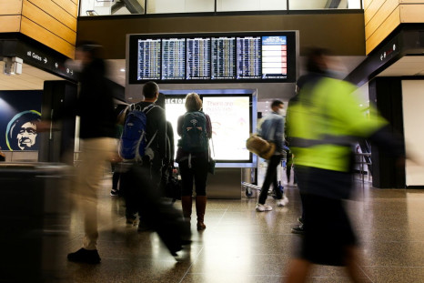 Travellers check a departures list at the ticketing level of Seattle-Tacoma International Airport in Seattle, Washington, U.S. November 24, 2021. 