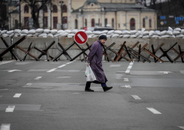A woman crosses the street as anti-tank constructions are seen in central Kyiv, Ukraine March 7, 2022.