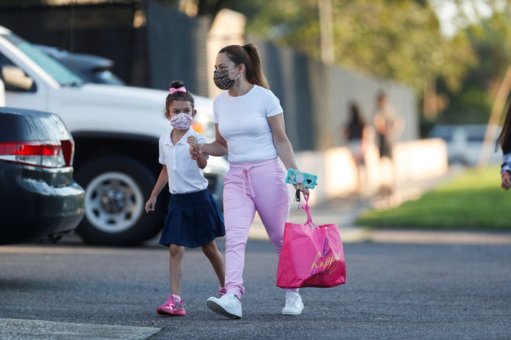 A mother walks her daughter on the first day of school, amid the coronavirus (COVID-19) pandemic, at West Tampa Elementary School in Tampa, Florida, U.S., August 10, 2021.