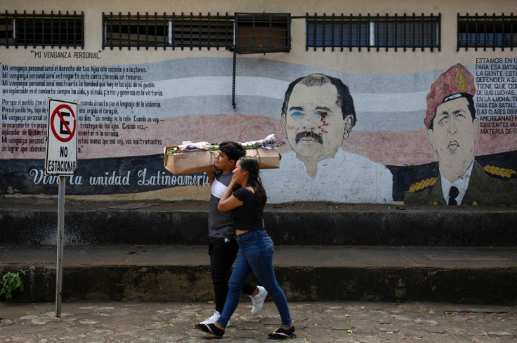 People walk past a mural showing Nicaraguan President Daniel Ortega and late Venezuelan president Hugo Chavez ahead of Ortega's swearing-in ceremony after being re-elected for a fourth consecutive term, in Managua, Nicaragua January 7, 2022.