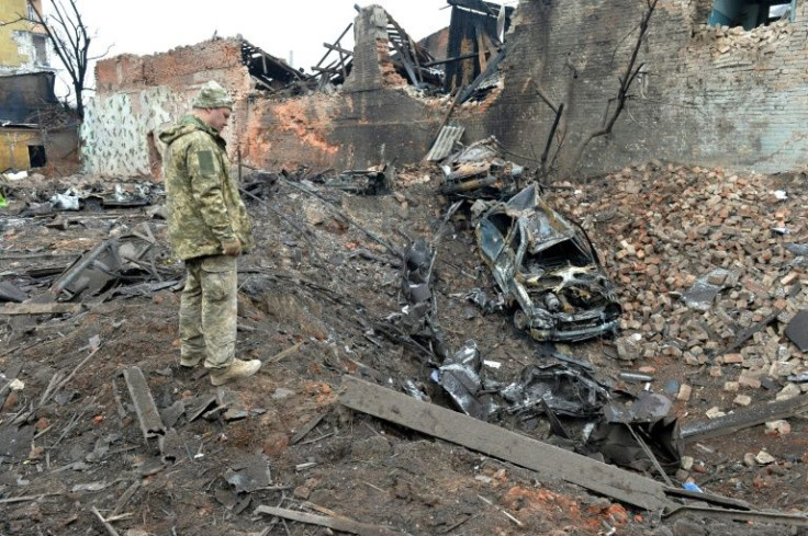 A Ukrainian serviceman looks at the destruction caused by shelling in Kharkiv on March 7
