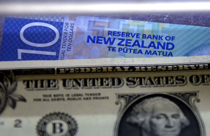 A New Zealand ten dollar note sits underneath a United States one dollar bill in the window of a currency exchange teller in Sydney, Australia, March 10, 2016.     