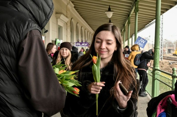 In the Polish border city of Przemysl, a priest handed out tulips at the train station
