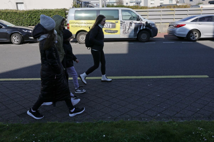 Ukrainian refugees, fleeing Russia's invasion of Ukraine, walk past a van outside a youth hostel for refugees in Calais, France, March 8, 2022.