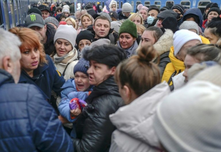 People rush to board trains out of the Ukrainian port of Odessa, which is bracing for an attack