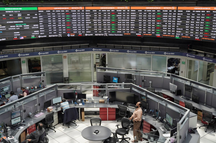 Employees work at their positions as a ticker displays stock exchange data at Mexico's stock exchange, in Mexico City, Mexico June 1, 2021.
