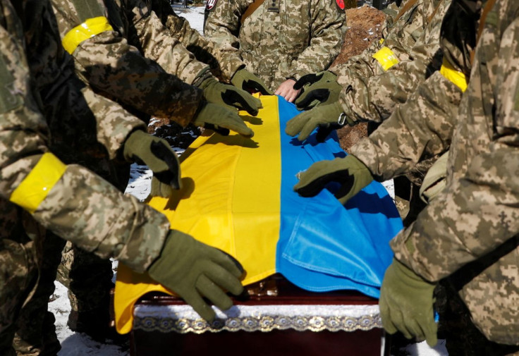 Members of the Honour Guard place the national flag to a coffin with a body of the member of the Ukrainian Armed Forces, Valerii, who was killed during Russia's invasion of Ukraine, during a funeral ceremony in Kyiv, Ukraine, March 8, 2022.  
