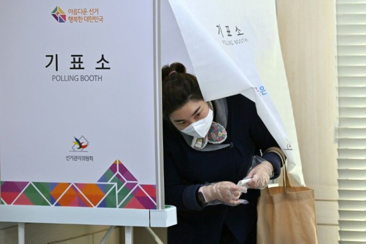 Voters have to wear masks and many spritz their hands with sanitiser after casting their ballot due to a wave of Omicron infections