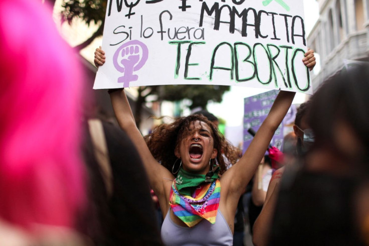 A woman holds up a sign during a protest to mark International Women's Day in Guatemala City, Guatemala March 8, 2022.