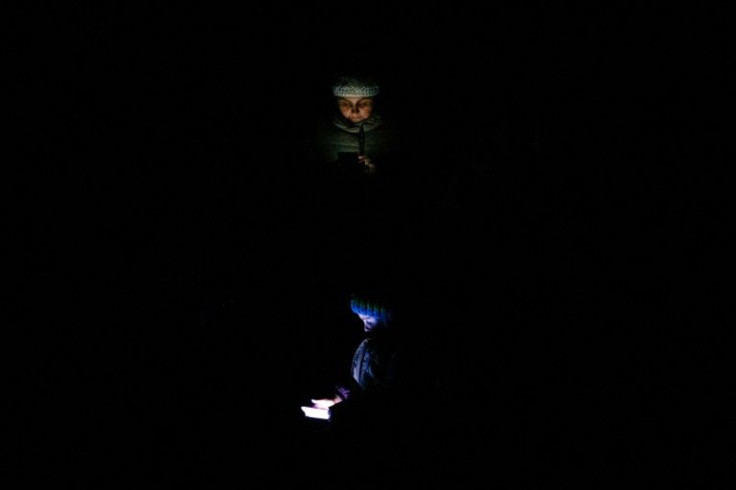 A woman and child look at their phones while they wait to board an evacuation train in Kyiv on March 5