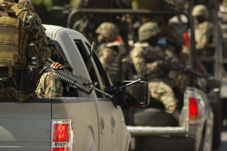 Soldiers ride on trucks while patrolling the streets of Morelia December 14, 2010. Mexico's spiraling war against powerful drug cartels escalated this week and clashes caused war-like scenes of burned-out and bullet-riddled cars around Michoacan'