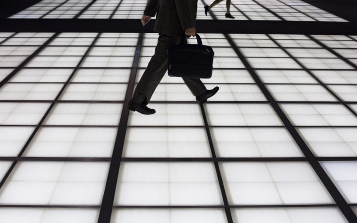 People cross an illuminated floor at a banking district in central Tokyo November 27, 2014.