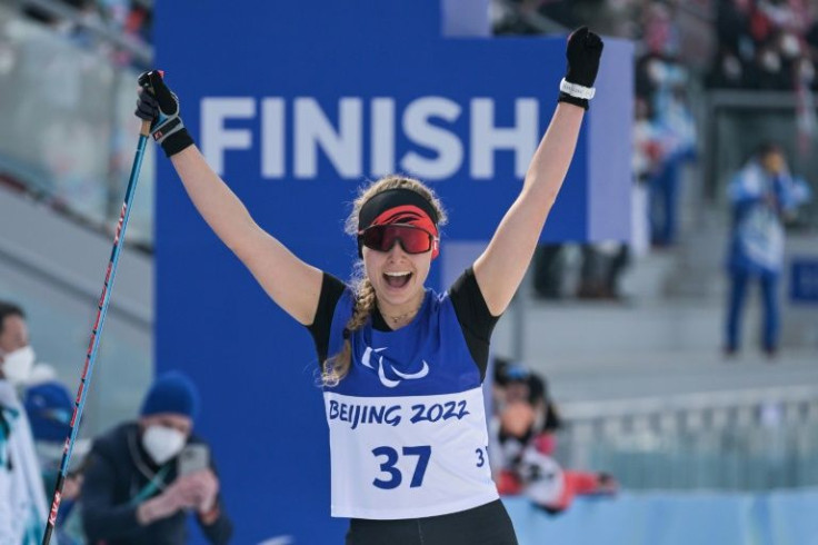 Canada's Natalie Wilkie celebrates after crossing the finishing line -- wearing short sleeves