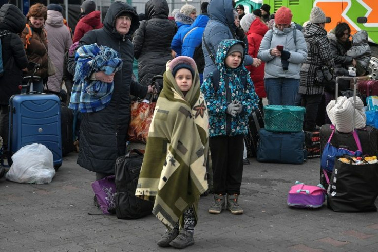 Ukrainian refugees wait to board buses taking them further into Poland or abroad from a temporary shelter on the border