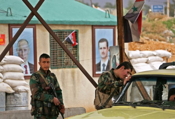 Syrian regime forces man a checkpoint during the evacuation of people from the rebel-held enclave of Eastern Ghouta through safe corridors announced by Russia in February 2018