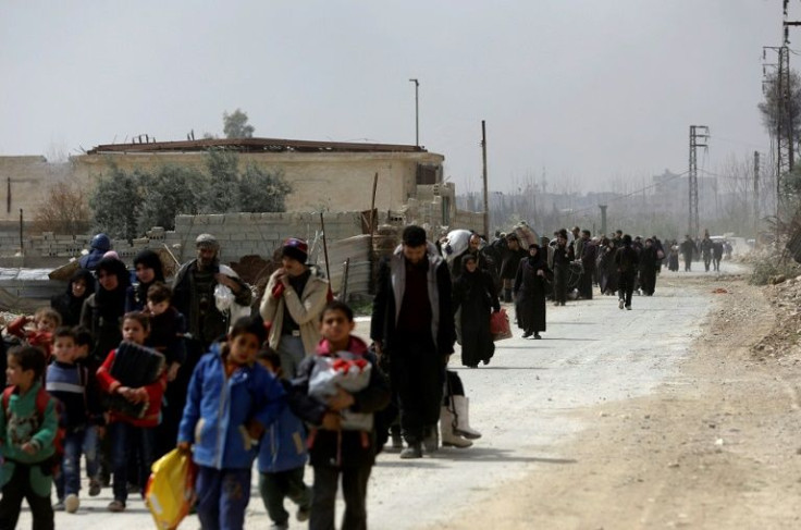 Syrians from rebel-held Eastern Ghouta walk through a regime-controlled corridor in 2018