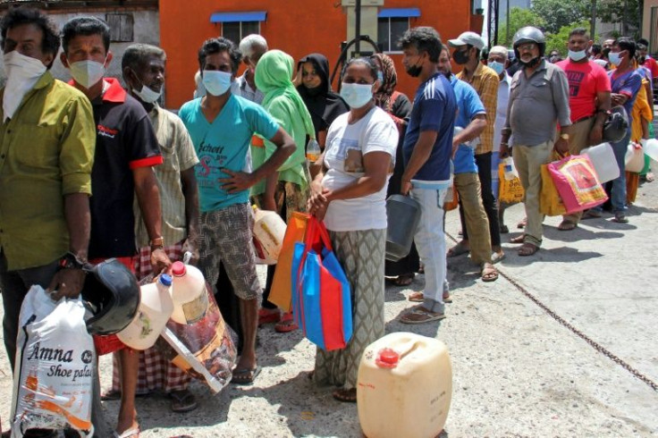 People queue to buy kerosene oil for their homes in Colombo as many essentials are in short supply