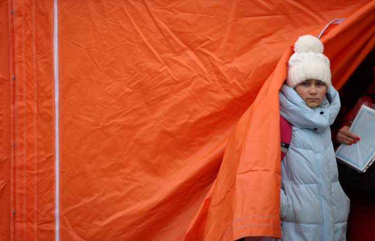 A girl stands in front of a tent following her arrival by ferry after fleeing from Russia's invasion of Ukraine, at the Isaccea-Orlivka border crossing, Romania, March 9, 2022.