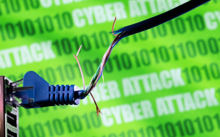 Broken Ethernet cable is seen in front of binary code and words "cyber attack" in this illustration taken March 8, 2022. 