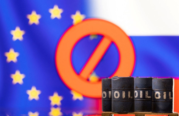 Models of oil barrels are seen in front of the displayed sign "stop", EU and Russia flag colours in this illustration taken March 8, 2022. 