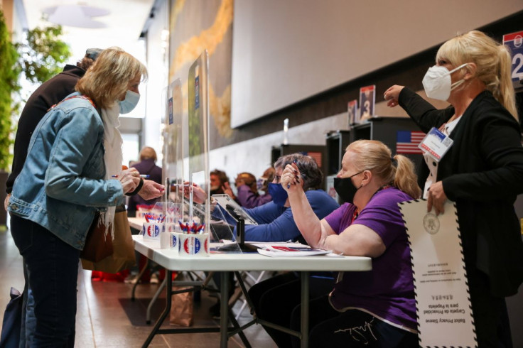 Poll workers help voters check in at the David Rubenstein Atrium at Lincoln Center on the first day of early voting in New York, U.S., October 23, 2021.