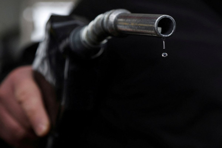 Gasoline drips out of a nozzle held by a gas station mechanic in Somerville, Massachusetts, U.S., March 7, 2022.  