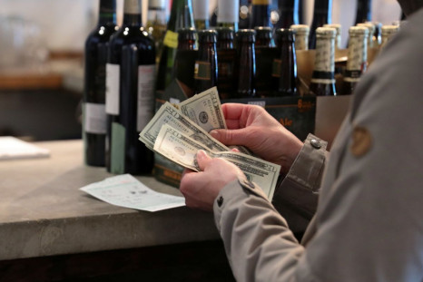 Customers pay cash to buy up stocks of wine, food and kitchen supplies as the French restaurant Montmartre closes after 20 years of operation on Capitol Hill due to financial pressures caused by the coronavirus disease (COVID-19) outbreak in Washington, U