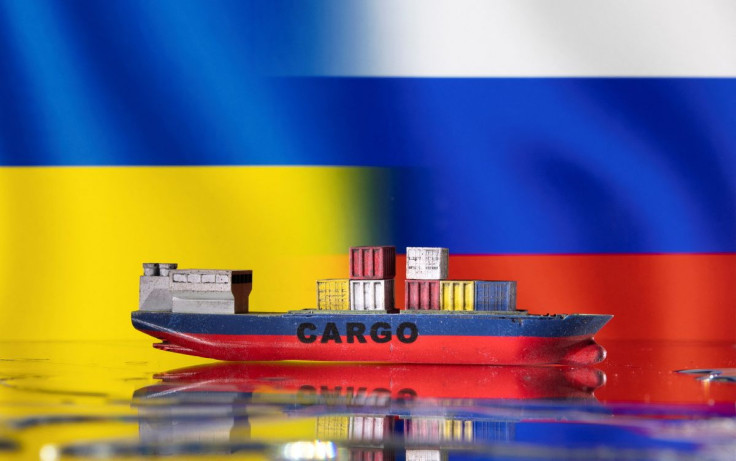 A cargo ship boat model is pictured in front of Ukraine's and Russian's flags in this illustration taken March 3, 2022. 