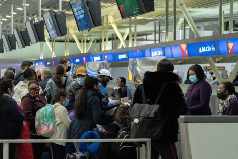 Travelers check in at John F. Kennedy International Airport during the spread of the Omicron coronavirus variant in Queens, New York City, U.S., December 26, 2021. 