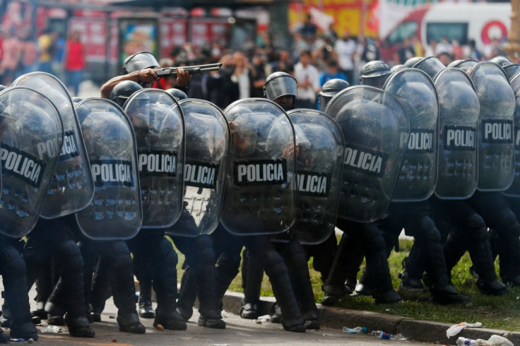 Police officers hide behind shields during a protest outside the National Congress, as members of the parliament debate the government's agreement with the International Monetary Fund (IMF), in Buenos Aires, Argentina March 10, 2022. 