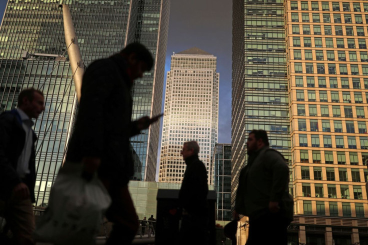 People walk through the Canary Wharf financial district of London, Britain, December 7, 2018. 