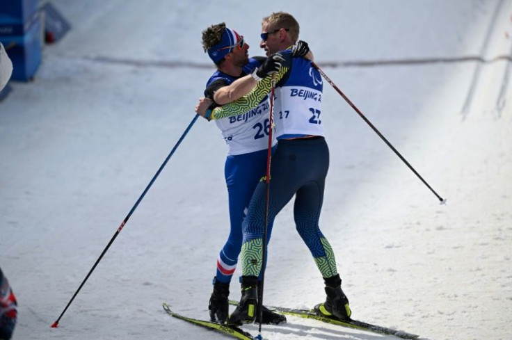 Franceâs Benjamin Daviet (L) hugs Ukraineâs Grygorii Vovchynskyi (R) after the menâs cross-country sprint free-standing final