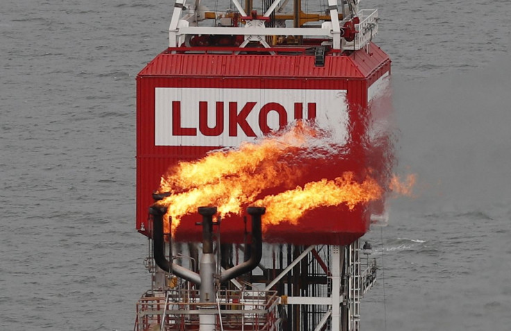 A gas torch is seen next to the Lukoil company sign at the Filanovskogo oil platform in the Caspian Sea, Russia October 16, 2018. 