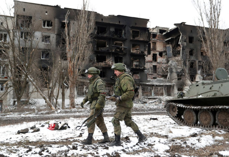 Service members of pro-Russian troops in uniforms without insignia walk near a residential building which was heavily damaged during Ukraine-Russia conflict in the separatist-controlled town of Volnovakha in the Donetsk region, Ukraine March 11, 2022. 