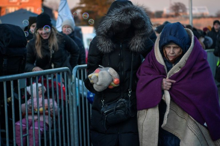 An elderly woman receives help after entering southeastern Poland from Ukraine at the Medyka border crossing