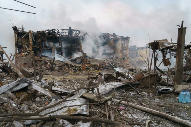 Firefighters spray water on a destroyed shoe factory following an air strike in Dnipro on March 11, 2022